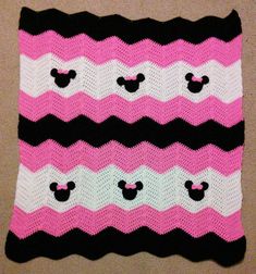 a crocheted blanket with mickey mouse ears on it, in pink and black