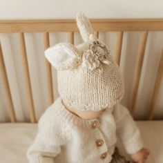 Soft hand knit beanie hat in Natural has stand-up bunny ears lined in natural yarn and trimmed in a pretty garland of flowers in shades of natural, cream, oatmeal and pebble. Perfect for Easter and Halloween wear, or anytime you want to look adorbs like a cute little cottontail!! 100% Acrylic Cold handwash Hand knit in China Bunny Beanie, Garland Of Flowers, Valentine Hats, Newborn Flower, Holiday Hats, Halloween Hats, Animal Hats, Holiday Baby, Plastic Pollution