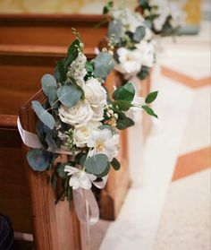 flowers and greenery line the pews of a church