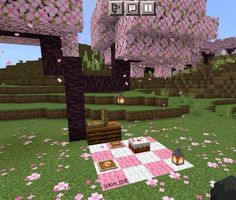 a pink and white checkered table in the middle of a field with flowers on it