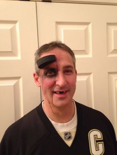 a man with his face painted like a hockey player is standing in front of a door