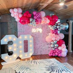 a room decorated with balloons and lights for an 80th birthday party