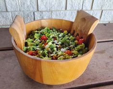 a wooden bowl filled with lots of vegetables