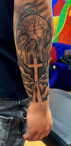 a man with a cross and clock tattoo on his arm