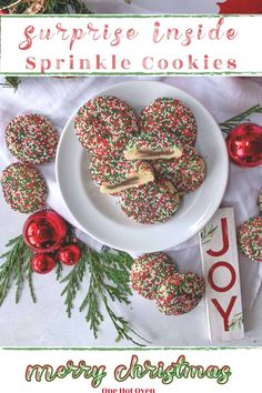 a white plate topped with sprinkle cookies next to christmas decorations