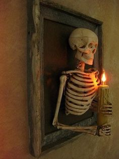 a skeleton holding a lit candle in it's hand