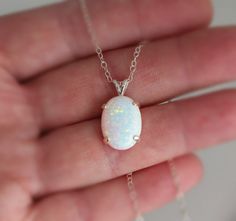 "Beautiful Large white lab-created opal pendant necklace. These gorgeous opals are very similar to natural mined opals. Lab-created opals contain 70-90% silica (from which natural opal is formed) and 10-30% resin. The resin makes the opal harder, stronger, unlike natural opals, which are known to be soft and fragile. Each opal displays a rainbow of color that sparkles with every catch of light. I've handset two different size opals in a solid sterling silver prong settings 16x12mm (5/8\" x 1/2\" White Opal Birthstone Jewelry, Elegant White Pink Opal Jewelry, White Oval Opal Necklace, White Ethiopian Opal Gemstone Jewelry, White Opal Round Pendant Necklace, White Opal Jewelry Gift, White Opal Necklace For Gift, White Ethiopian Opal Cabochon Jewelry, White Ethiopian Opal Gemstone Necklace