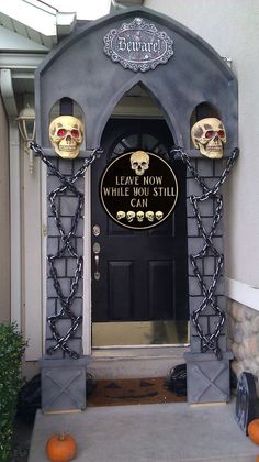 an entrance to a house with pumpkins on the ground and decorations around it,