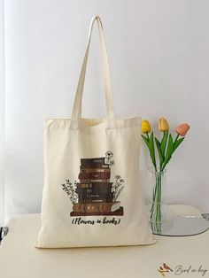 a tote bag sitting on top of a table next to a vase with flowers