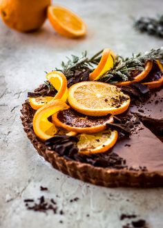 a chocolate tart topped with orange slices and rosemary