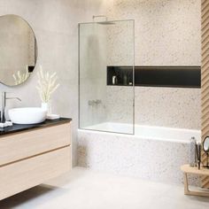 a bathroom with a sink, mirror and bathtub next to a wall mounted shower