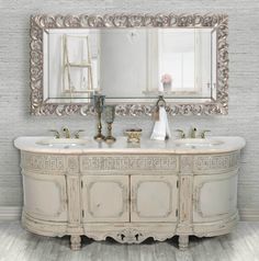 a bathroom vanity with two sinks and a large mirror over it's sideboard