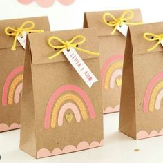 three small brown bags with rainbows on them