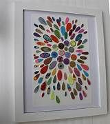 an art piece is hanging on the wall in front of a white frame with multicolored circles