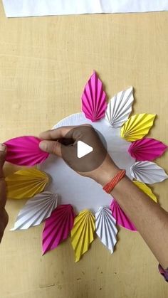 someone is making an origami flower out of paper