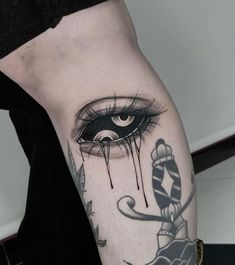 a woman's leg with a tattoo on it that has an eye and a candy cane