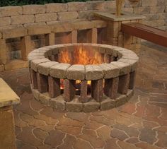 an outdoor fire pit is shown with candles in it