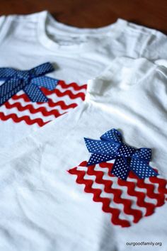 an american flag t - shirt with bows on the front and back, sitting on a table