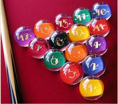 a pool table with many different colored balls and cuesticks next to each other