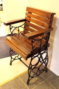 a wooden bench sitting next to a white wall