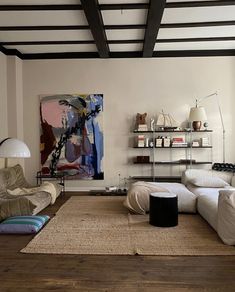 a living room filled with furniture and a painting on the wall