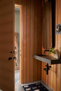 a bathroom with wood paneling and a plant on the shelf next to the door