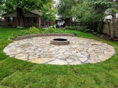 a stone fire pit surrounded by green grass