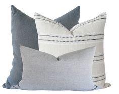 two gray and white pillows sitting next to each other