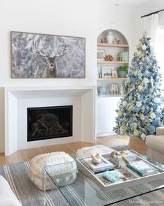 a living room filled with furniture and a christmas tree in front of a fire place