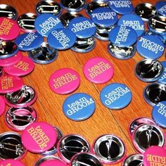 buttons with the words happy birthday on them are arranged in a circle and placed on a wooden surface