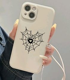 a woman holding up her phone case with a spider web on it