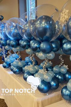 blue balloons and snowflakes are arranged on a table