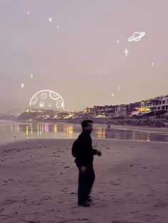 a man standing on top of a sandy beach under a sky filled with white stars