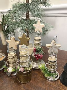 a wooden table topped with jars filled with christmas tree decorations and stars on top of them