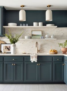 a kitchen with blue cabinets and marble counter tops