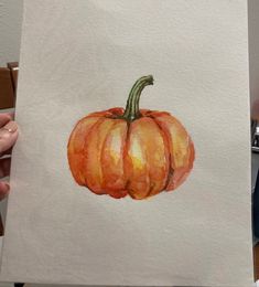 a watercolor painting of a pumpkin on white paper