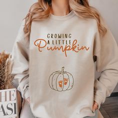 "Growing A Little Pumpkin Sweatshirt Fall Maternity Sweater Pregnancy Thanksgiving Shirt Fall Pregnancy Announcement Gift Pregnancy Reveal  Premium Quality Printed in the USA. HOW TO ORDER ----------------------- 1-) Check and Review all Photos. 2-) Select Your T-Shirt Size from drop down menu. 3-) Choose Your Quantity you want. 4-) Click ADD TO CART. And, you can go back to add more product for your family members or You can complete the checkout process. 5-) Please Click \"Proceed to Check Out\" 6-) Your order will be ready to ship 2-5 Business Day. ABOUT US --------------- We are a husband-and-wife team who believe that beauty is all around us, and we strive to capture it in our designs. Thank you for choosing to shop with us, and we hope you find something that inspires you! For custom Baby Reveal Shirt, Fall Pregnancy, Fall Pregnancy Announcement, Thanksgiving Sweater, Pregnancy Reveal Shirt, Thanksgiving Sweatshirt, Pumpkin Sweatshirt, Pregnant Halloween, Pregnancy Announcement Gifts