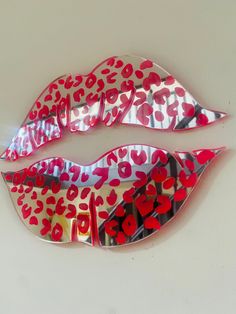 two red and black lips with hearts on them are shown in the shape of mirrors