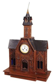 a wooden clock tower with a steeple and two clocks on the top of it