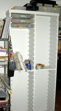 a white storage cabinet filled with lots of clutter