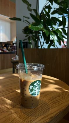 a starbucks drink sitting on top of a wooden table