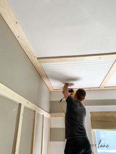 a man is painting the ceiling in his home