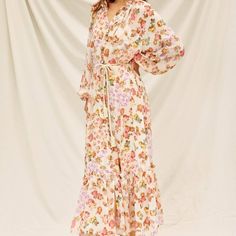 This beautiful maxi dress features a soft floral print and a stylish sash rope showcasing the perfect fit. With a ruffled neckline, front button closures, long balloon sleeves, a sash rope, and a ruffle tiered hem, this dress is sure to make a statement. Material: Slip lining Shell: 100% Polyester Lining: 100% Polyester Cream Long Sleeve Maxi Dress With Floral Print, Spring Long Sleeve Maxi Dress With Tie Waist, Spring Maxi Dress With Tie Waist And Long Sleeves, Bohemian Maxi Dress With Tie Waist For Garden Party, Flowy Feminine Maxi Dress With Tie Waist, Feminine Flowy Maxi Dress With Tie Waist, Spring Cream Maxi Dress With Floral Print, Flowy Maxi Dress With Tie Waist For Garden Party, Feminine Maxi Dress With Tie Waist For Daywear