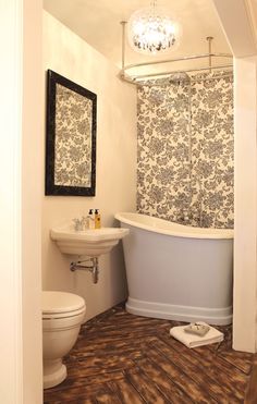 a bath room with a toilet a sink and a bath tub next to a mirror