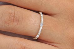 a woman's hand with a diamond ring on her left finger and the band is in white gold