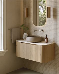 a bathroom sink sitting under a mirror next to a wall mounted faucet in front of a window