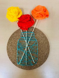 three flowers in a vase made out of yarn