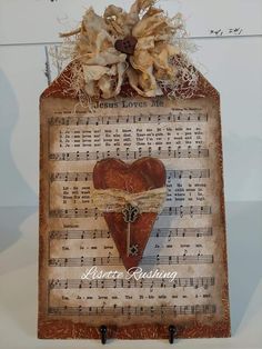 a wooden sign with sheet music and a heart on it's side, hanging from a wall