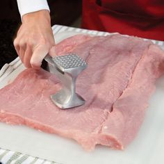 a person using a grater to grate meat on a cutting board with a pink towel