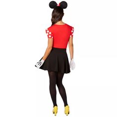 a woman dressed in minnie mouse costume and holding a handbag with her back to the camera